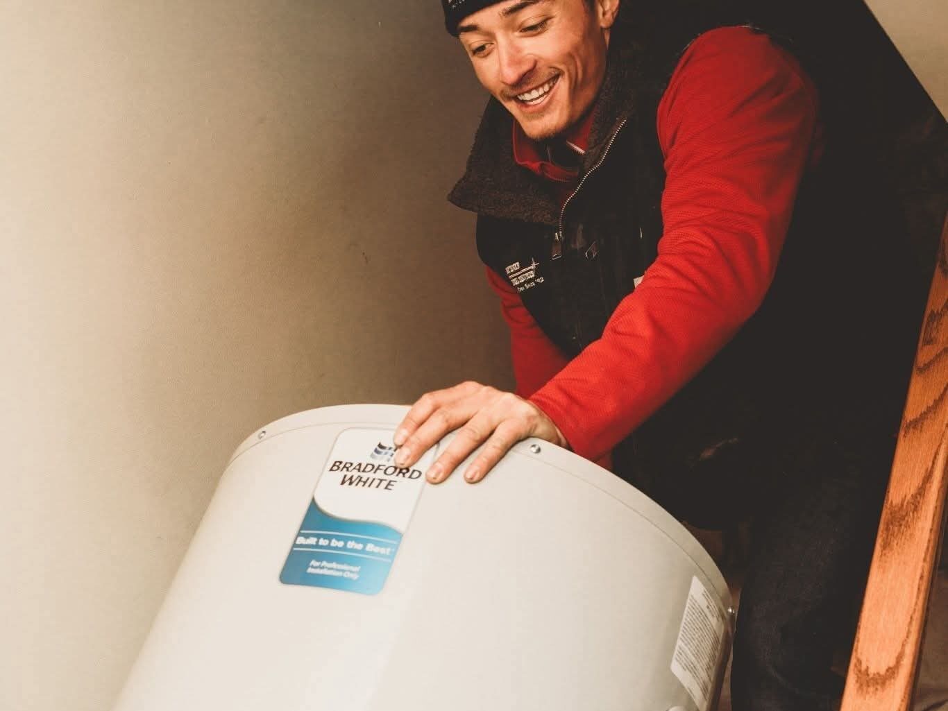 Guy carrying a water tank to the basement